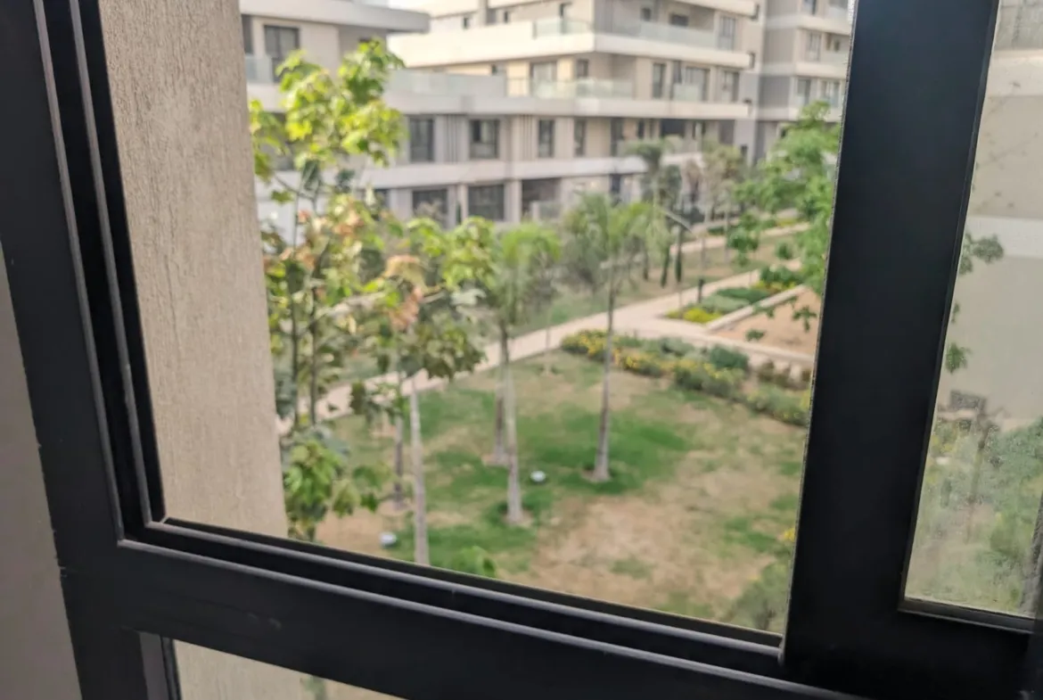 إطار شباك يطل على نجيل الحدائق والعمارات - شقة في سوديك فيليت، القاهرة الجديدة