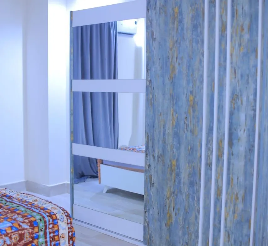 Bedroom with a patterned bed cover and a decorative wall panel - apartment in El Yasmeen 1, New Cairo