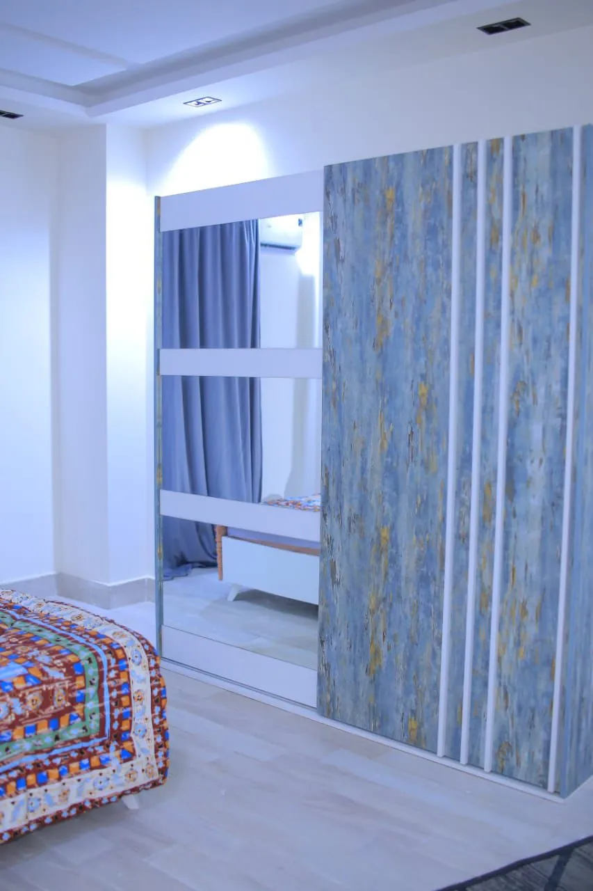 WhatsApp Image 2024-09-18 at 12.45.08 PM (3) Bedroom with a patterned bed cover and a decorative wall panel - apartment in El Yasmeen 1, New Cairo