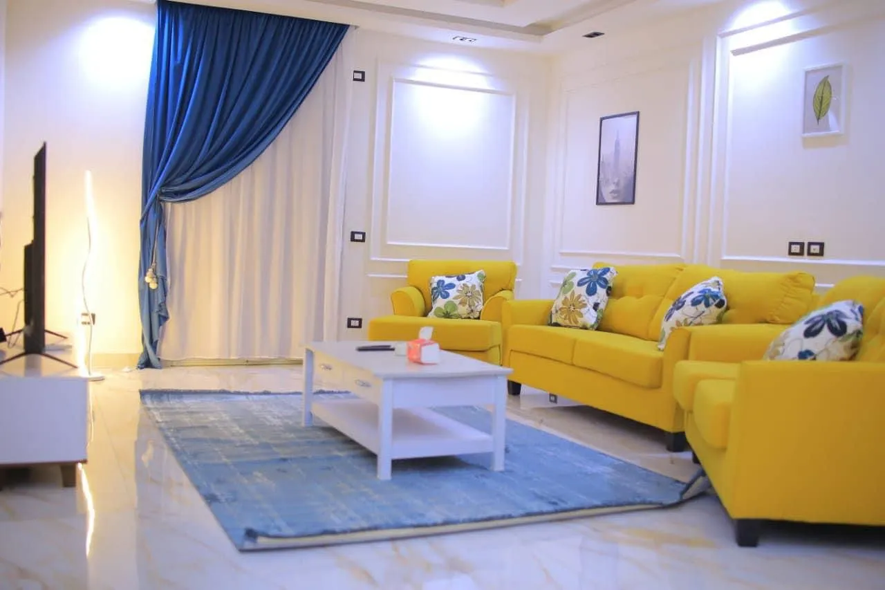 WhatsApp Image 2024-09-18 at 12.45.08 PM Living room with a yellow sofa set and a blue rug - apartment in El Yasmeen 1, New Cairo