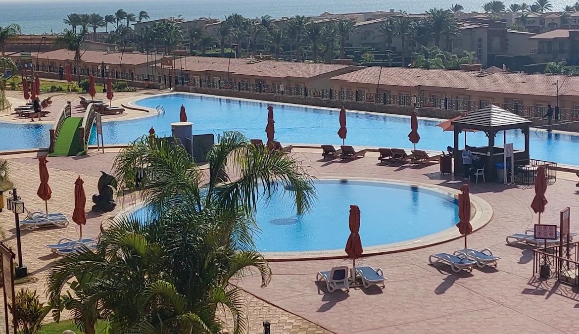 Resort pool area with umbrellas and bridge - apartment in Porto Sharm, Sharm El Sheikh