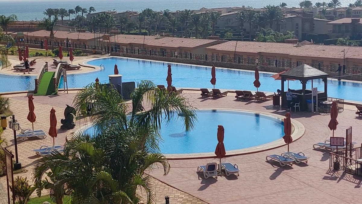 Resort pool area with umbrellas and bridge - apartment in Porto Sharm, Sharm El Sheikh