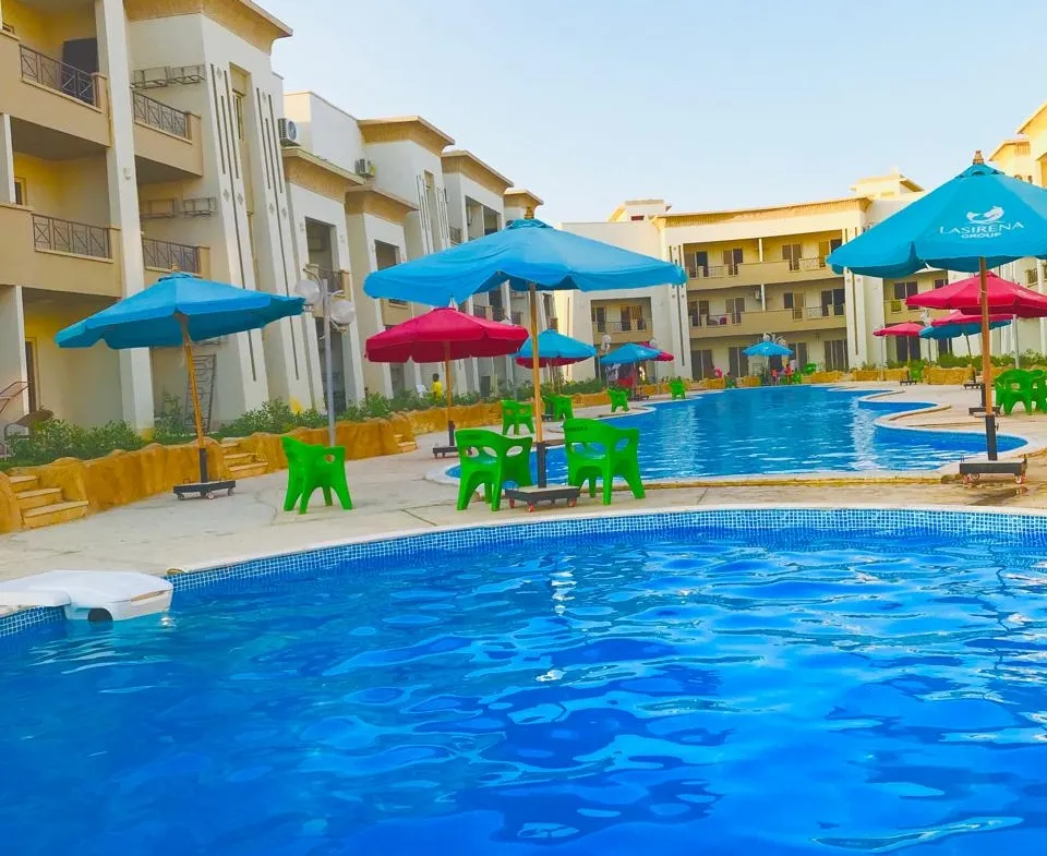 حمام سباحة بين مبان سكنية صفراء - شاليه في ريد كاربت بالعين السخنة