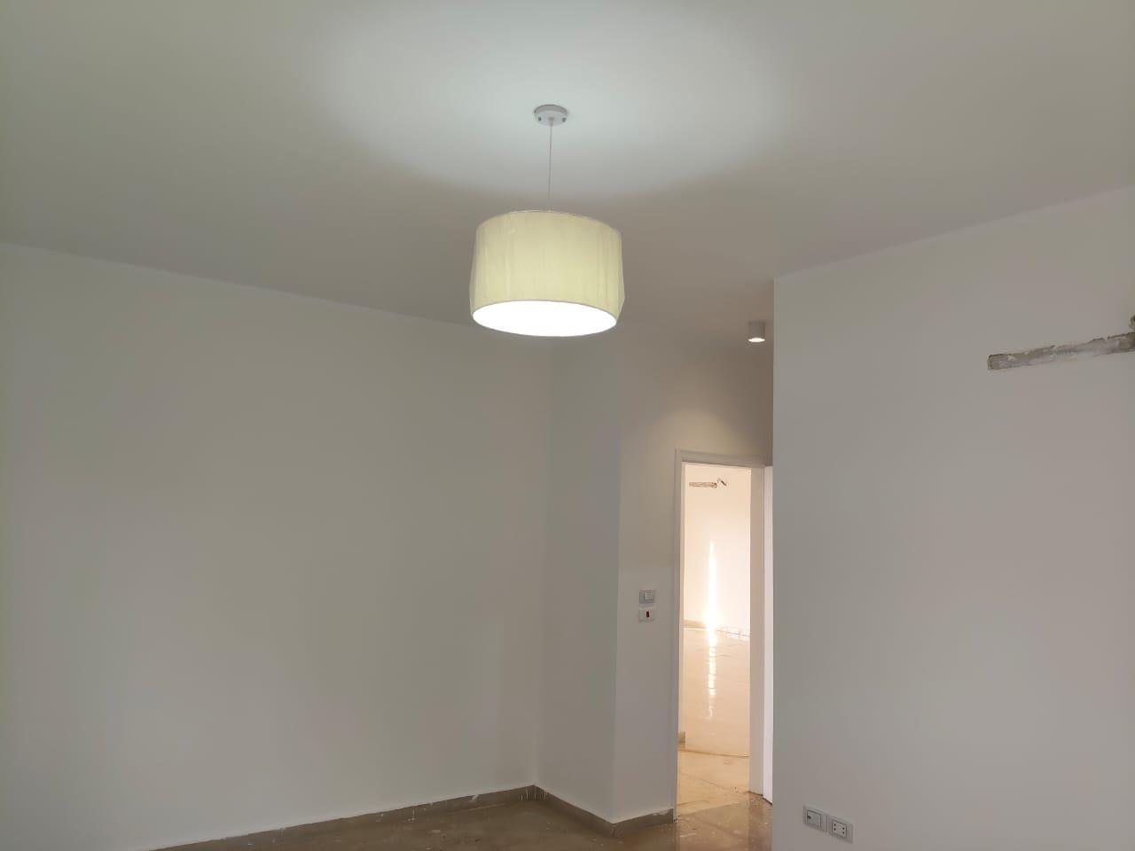 property-image-69ebfd2145c52 Room with a drum pendant light and a white door - apartment in Capital Gardens, New Cairo