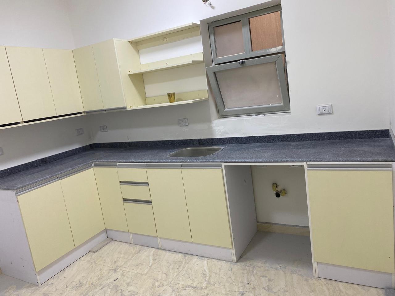 property-image-69ebfd27dd704 Kitchen with cream cabinets and a dark counter - apartment in Capital Gardens, New Cairo