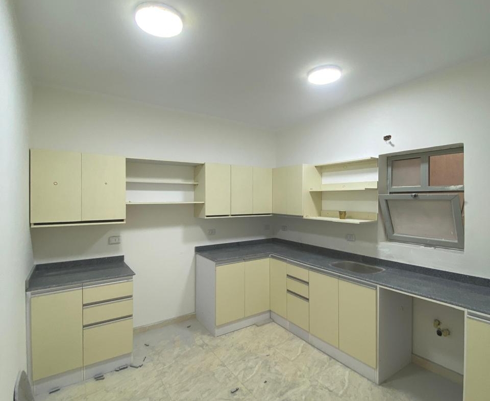 Kitchen with cream cabinets and recessed ceiling lights - apartment in Capital Gardens, New Cairo