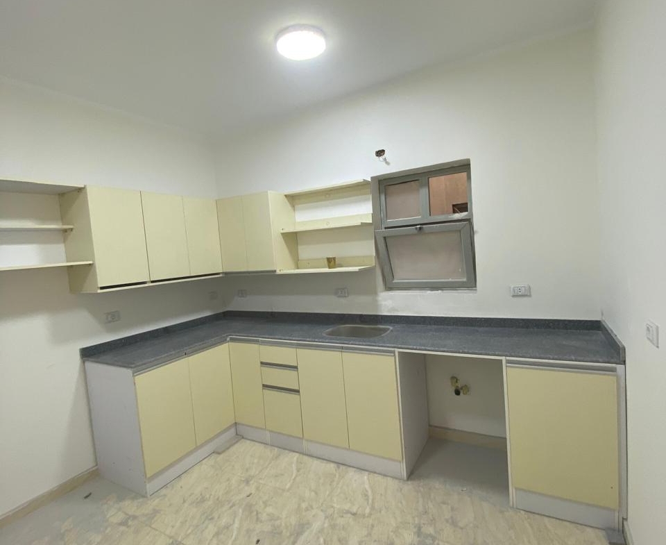 Corner kitchen with a dark counter and a marbled floor - apartment in Capital Gardens, New Cairo