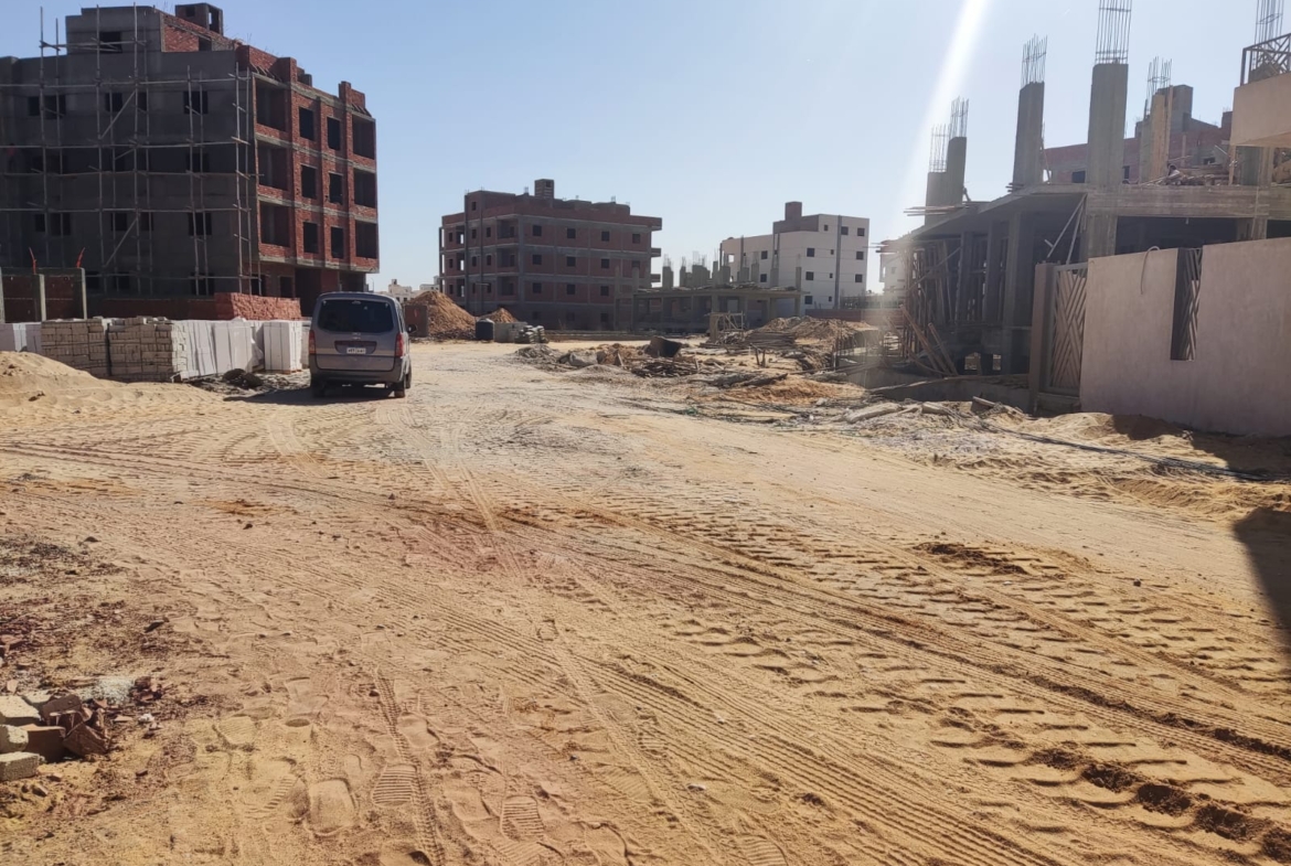 Sandy street with buildings under construction on both sides - apartment in Beit El Watan, New Cairo