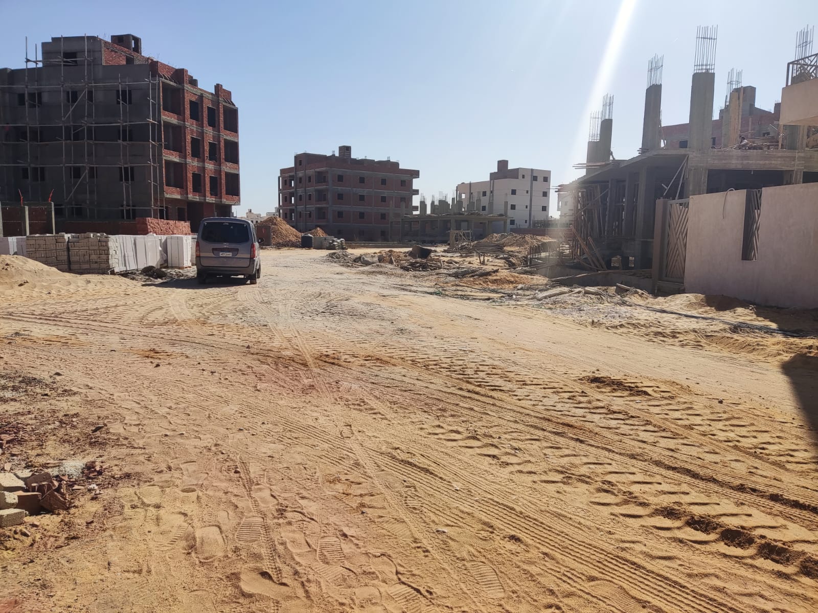 Sandy street with buildings under construction on both sides - apartment in Beit El Watan, New Cairo