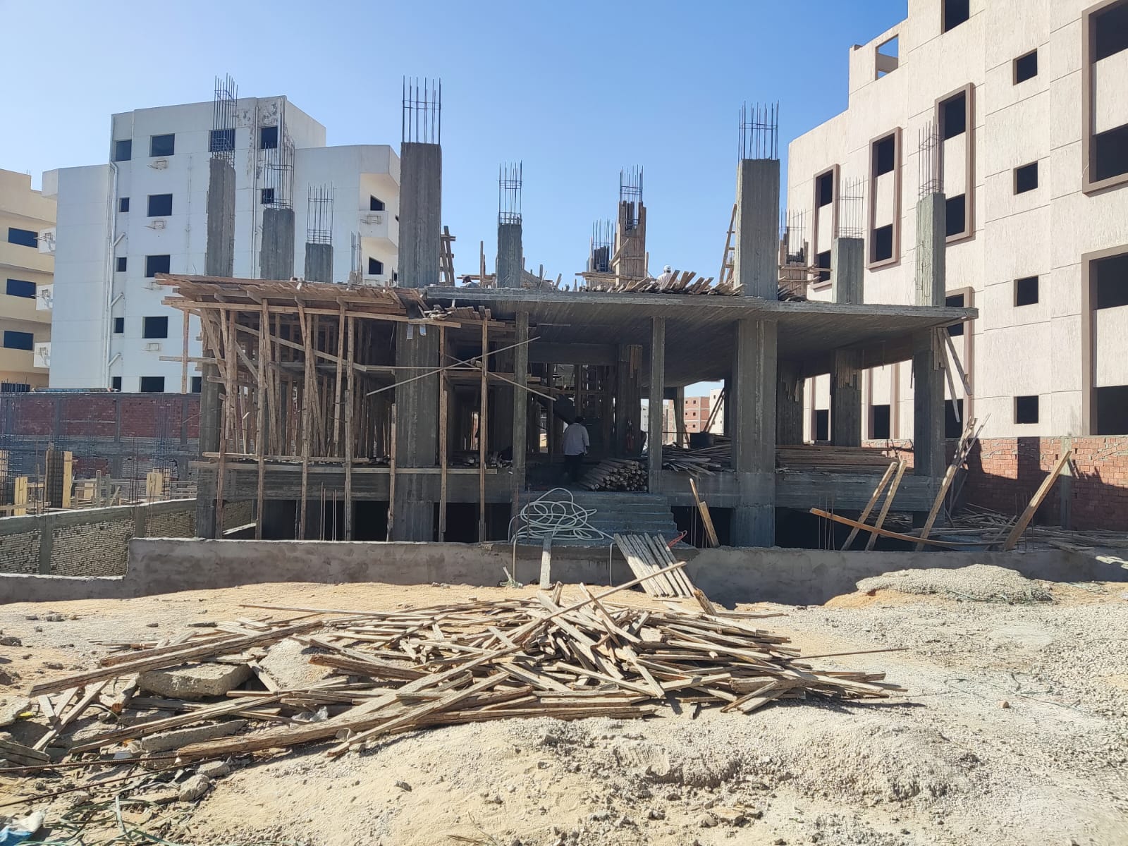 Concrete columns of a building under construction with timber on the ground - apartment in Beit El Watan, New Cairo