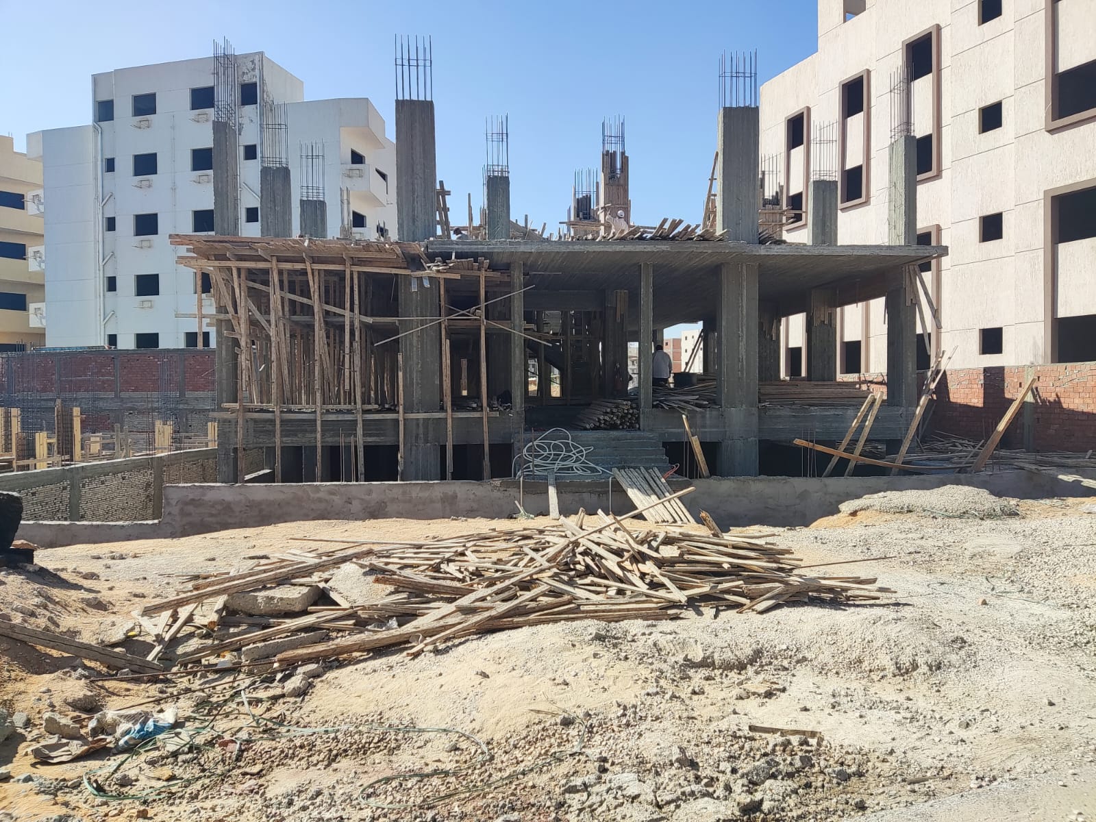 Building frame under construction between finished apartment blocks - apartment in Beit El Watan, New Cairo