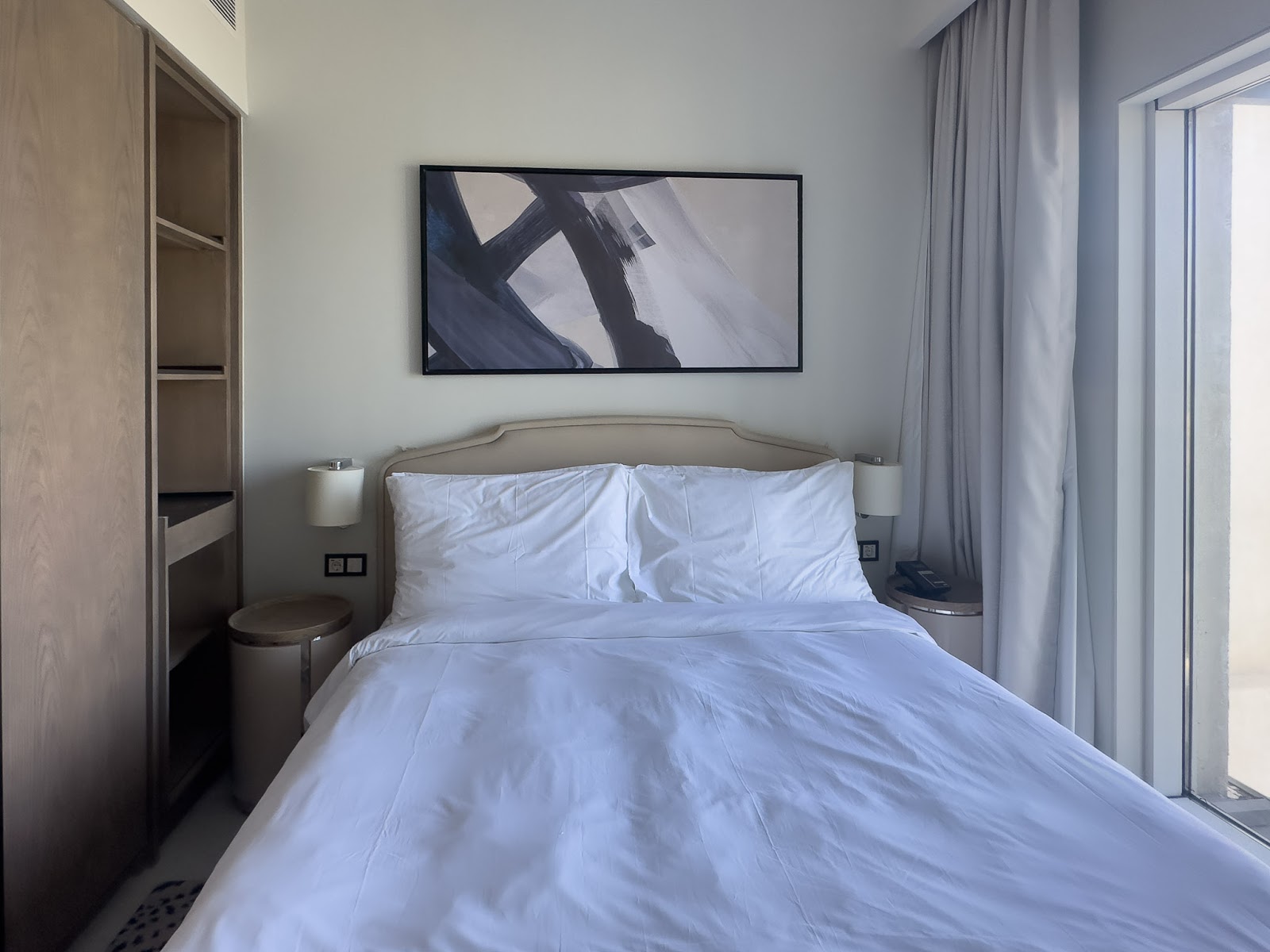 Double bed with padded headboard and abstract painting - hotel apartment in Marassi The Address Beach, North Coast