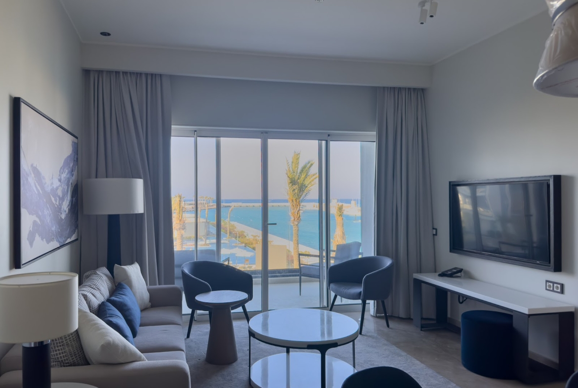 Living room with sea view, television and blue armchairs - hotel apartment in Marassi The Address Beach, North Coast