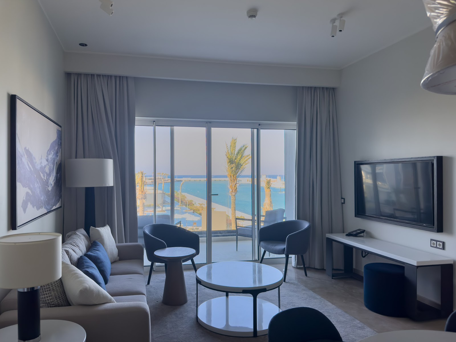 Living room with sea view, television and blue armchairs - hotel apartment in Marassi The Address Beach, North Coast