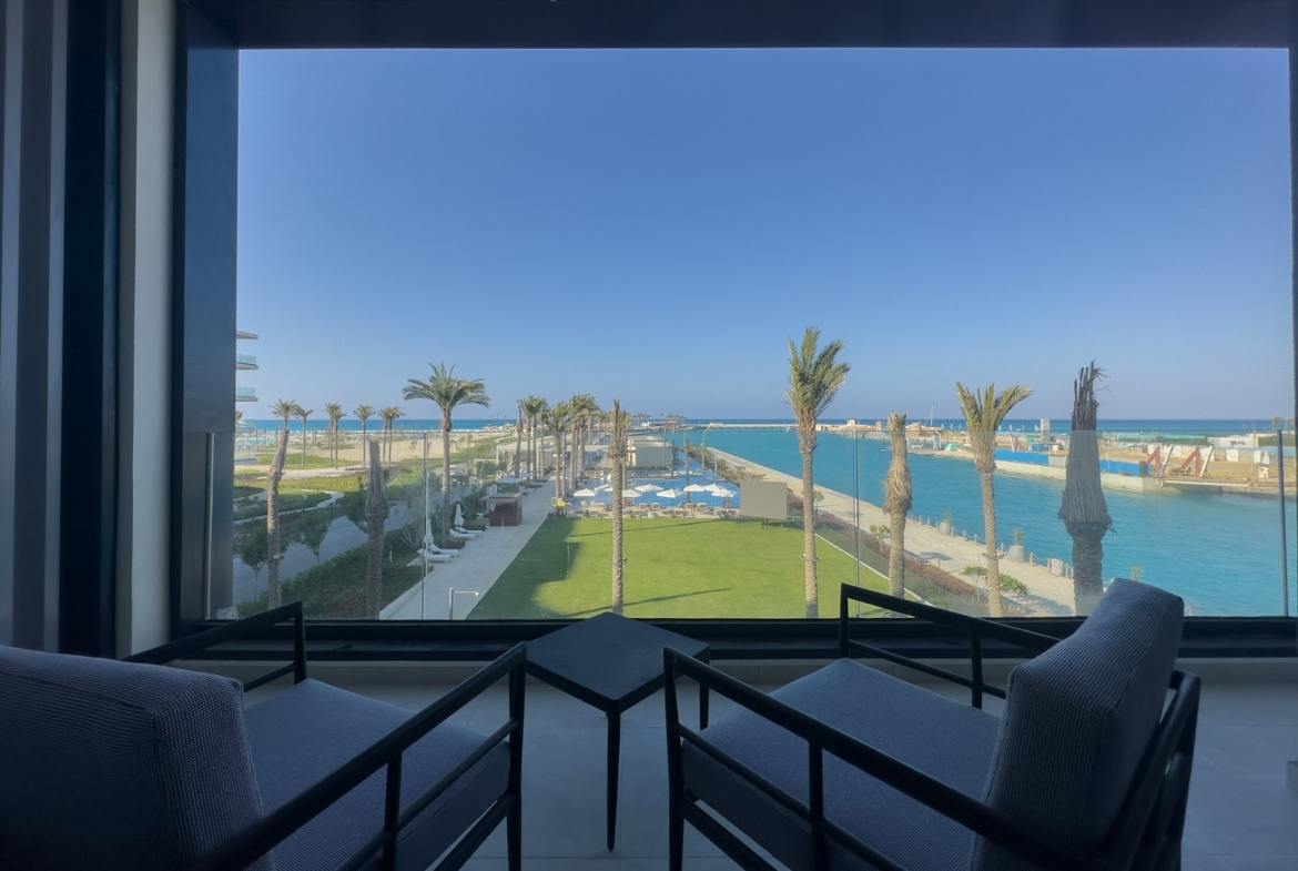 Balcony chairs facing the marina and green lawn - hotel apartment in Marassi The Address Beach, North Coast