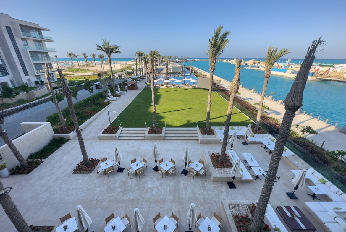 Terrace with sun loungers and umbrellas beside the marina - hotel apartment in Marassi The Address Beach, North Coast