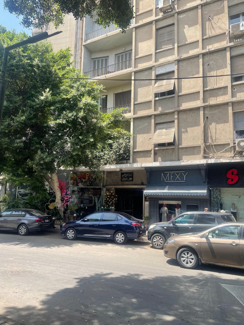 Building facade with parked cars - shop in Zamalek