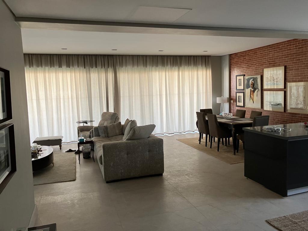 Furnished living and dining area with sheer curtains and a brick wall - penthouse in Lake View, New Cairo