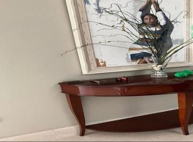 Console table with a framed picture above it - penthouse in Lake View, New Cairo