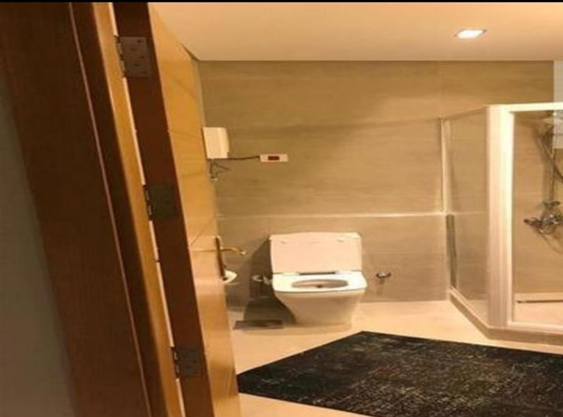 Bathroom with a wall-hung toilet and a glass shower - penthouse in Lake View, New Cairo