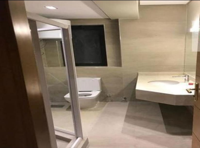 Guest bathroom with a glass partition and a wall-hung toilet - penthouse in Lake View, New Cairo