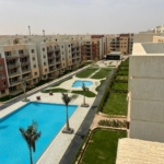 Long pool and lawns between apartment blocks seen from above - penthouse in Promenade, New Cairo
