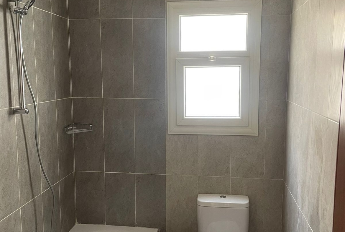 Bathroom with a bathtub, a toilet and a small window - penthouse in Promenade, New Cairo