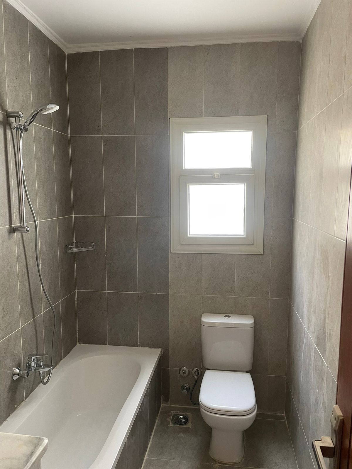 Bathroom with a bathtub, a toilet and a small window - penthouse in Promenade, New Cairo
