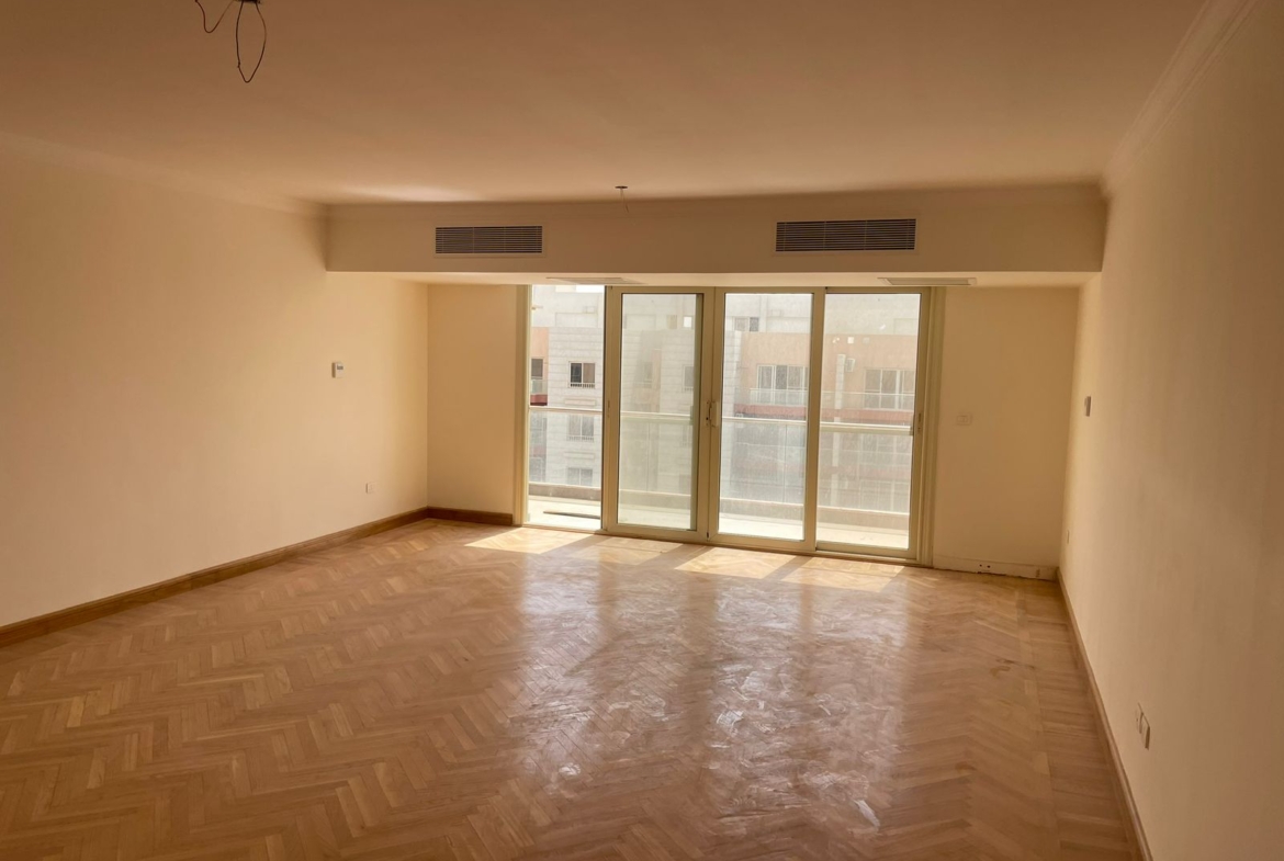Empty living room with glass doors and a parquet floor - penthouse in Promenade, New Cairo