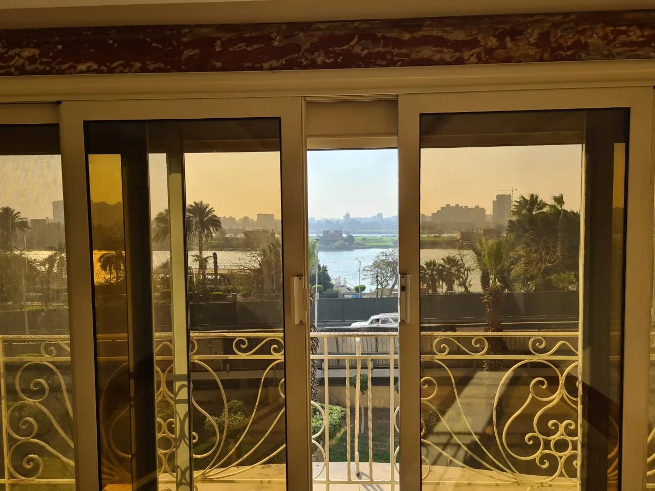 property-image-69f005c7052d1 غرفة معيشة مع أبواب بلكونة مزخرفة - شقة في كورنيش النيل، المعادي