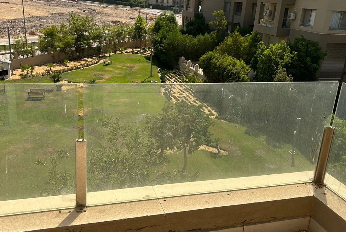 Glass-railed balcony looking at gardens and neighbouring buildings - duplex in Village Gate, New Cairo