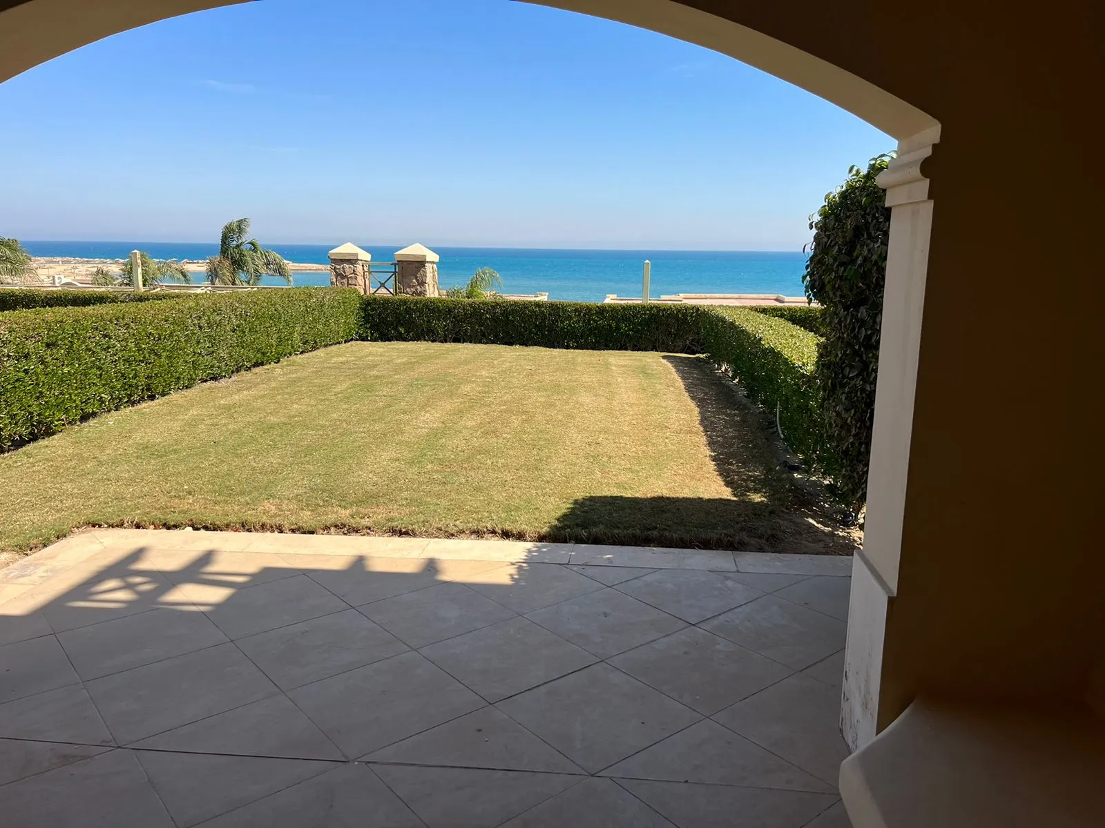 Covered terrace framing a garden and sea view - villa in La Vista 1, Ain Sokhna