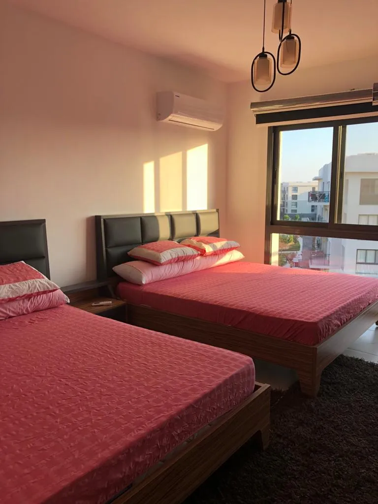 Bedroom with twin beds and red bedspreads in Marassi, North Coast