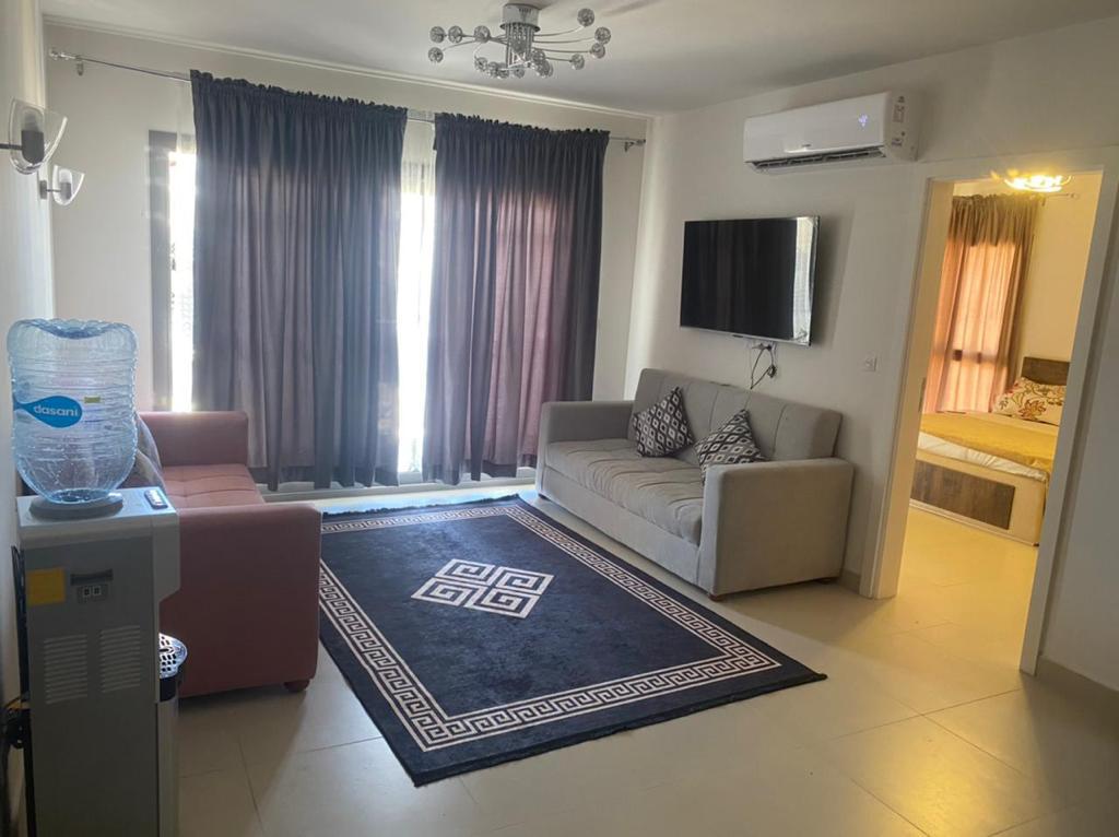 Living room with a beige sofa and a balcony with dark curtains - chalet in Marassi Marina 2