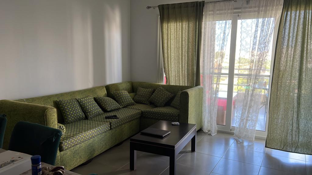 Green corner sofa near the balcony door - chalet in Amwaj, North Coast