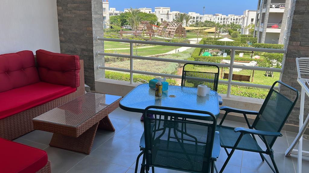 Balcony seating and a glass table with garden view - chalet in Amwaj, North Coast