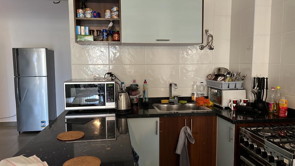 Kitchen corner with fridge and white tiled wall - chalet in Amwaj, North Coast