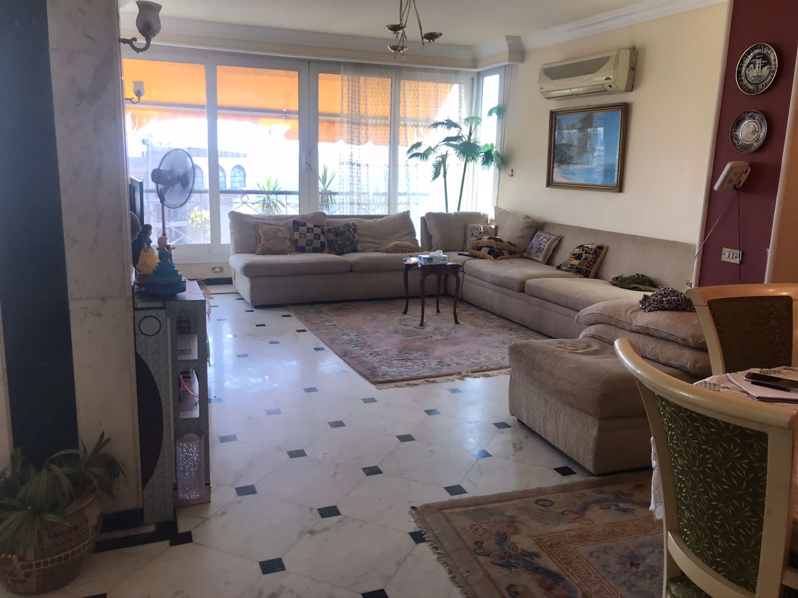 property-image-69f06297ec66e غرفة معيشة بأرضية رخامية ونوافذ واسعة - شقة في الزمالك القاهرة