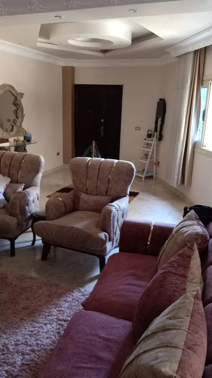 Sitting area with burgundy sofas and an armchair under a decorated ceiling - duplex in South of Academy, New Cairo