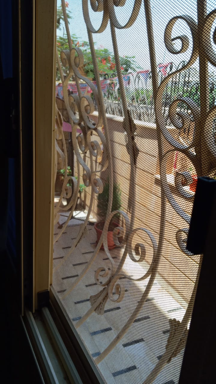Wrought-iron balcony railing seen through a window - duplex in South of Academy, New Cairo