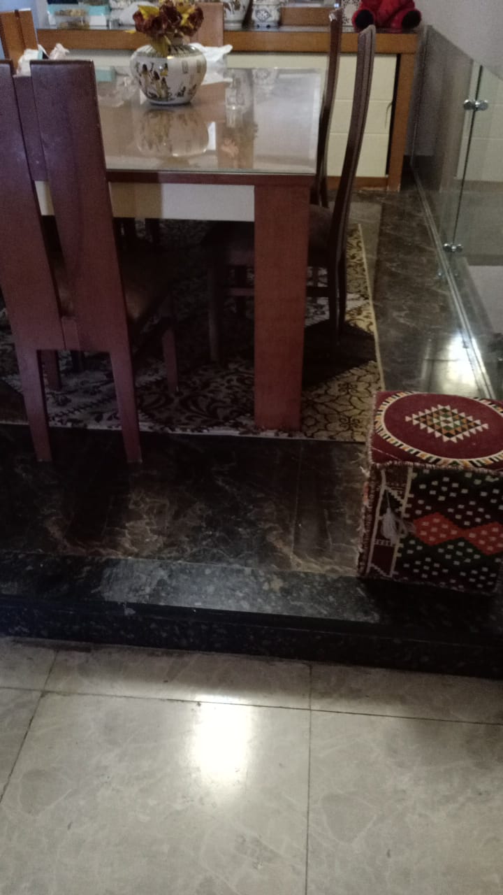 Wooden dining table on a polished marble floor - duplex in South of Academy, New Cairo