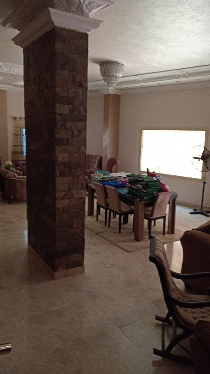 Dining area behind a stone-clad column - duplex in South of Academy, New Cairo
