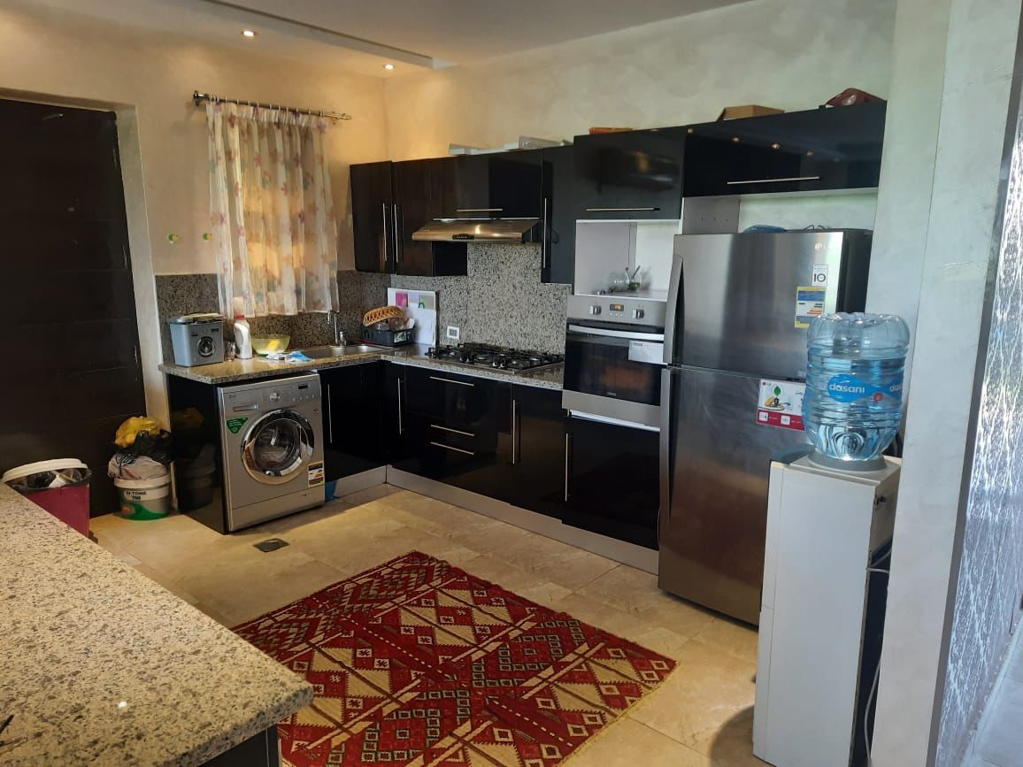property-image-69f0746aafab1 مطبخ بدواليب سوداء وسجادة حمراء منقوشة - شاليه في هاسيندا باي، سيدي عبدالرحمن الساحل الشمالي