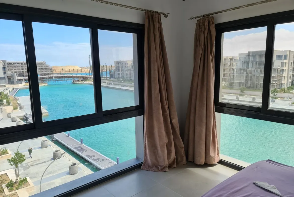 Window view of the turquoise lagoon and apartment buildings - studio in Marassi, North Coast