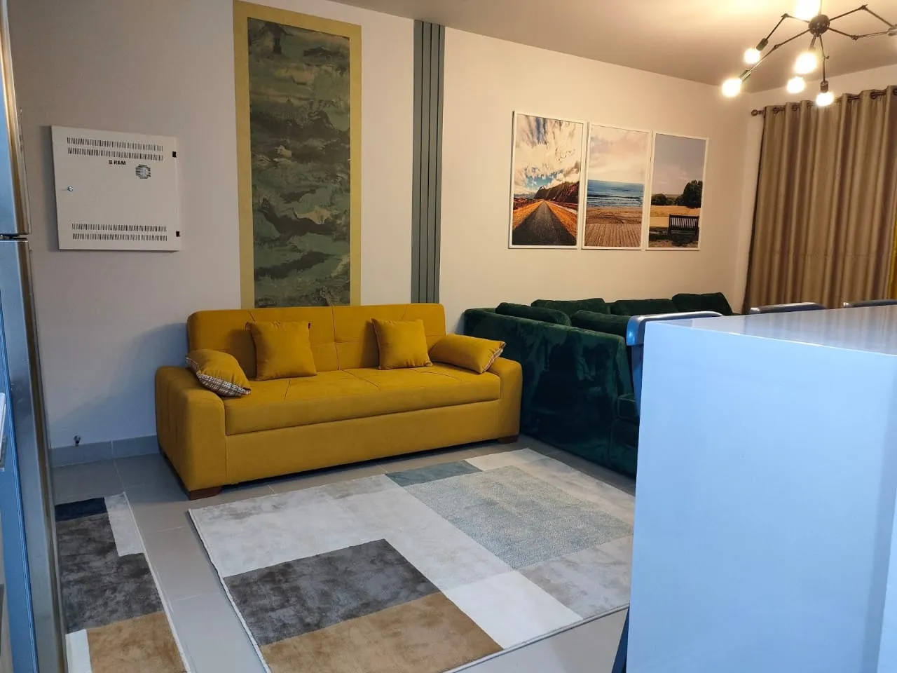 property-image-69f0a8e0e3905 Mustard sofa and green velvet sofa with artwork on the wall - chalet in Marassi Marina 1, North Coast