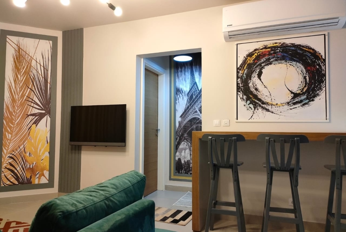 Wall television, green sofa and abstract artwork - chalet in Marassi Marina 1, North Coast