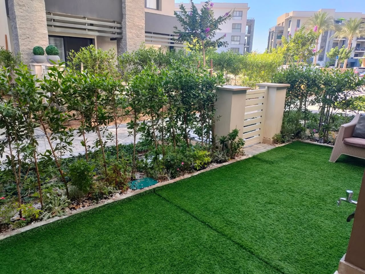 property-image-69f0a8f2e1489 Garden terrace with green lawn and flower beds - chalet in Marassi Marina 1, North Coast