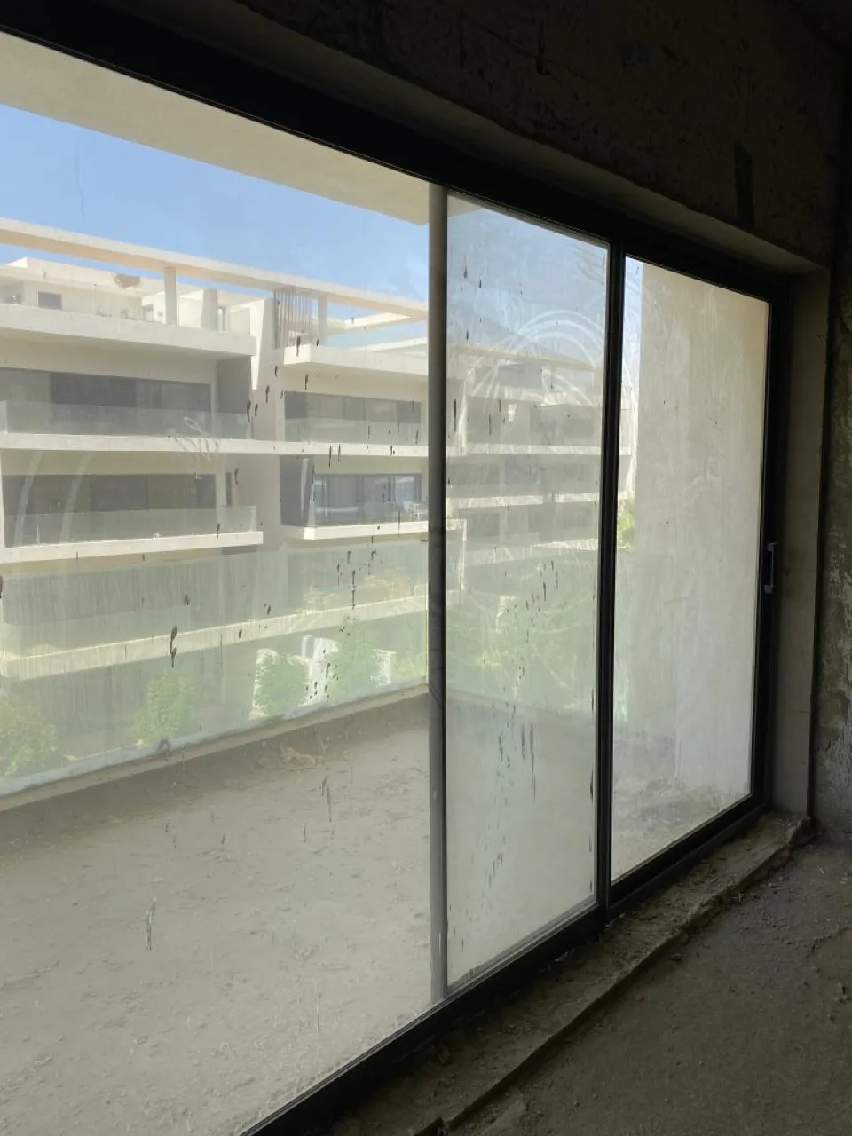شباك منزلق كبير يطل على عمارات سكنية - شقة في ليك فيو، القاهرة الجديدة