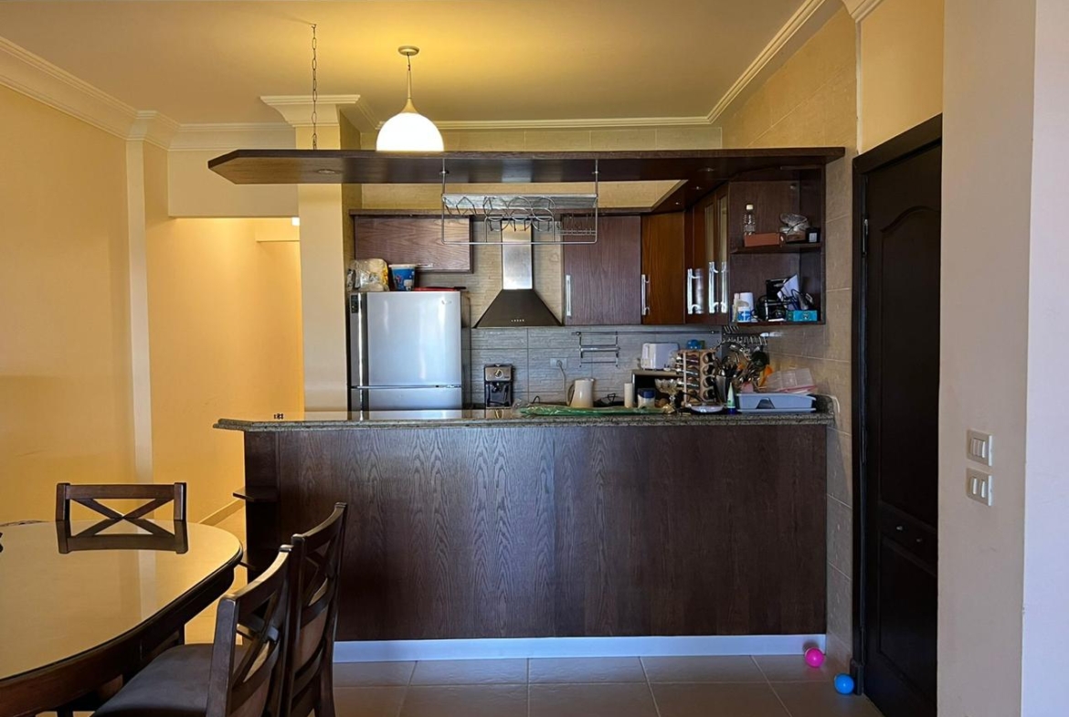 Open kitchen with a dark counter and dining chairs - chalet in La Vista Bay, North Coast