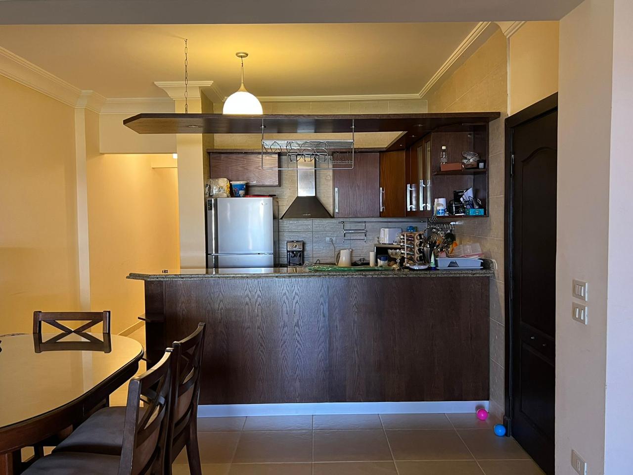 Open kitchen with a dark counter and dining chairs - chalet in La Vista Bay, North Coast